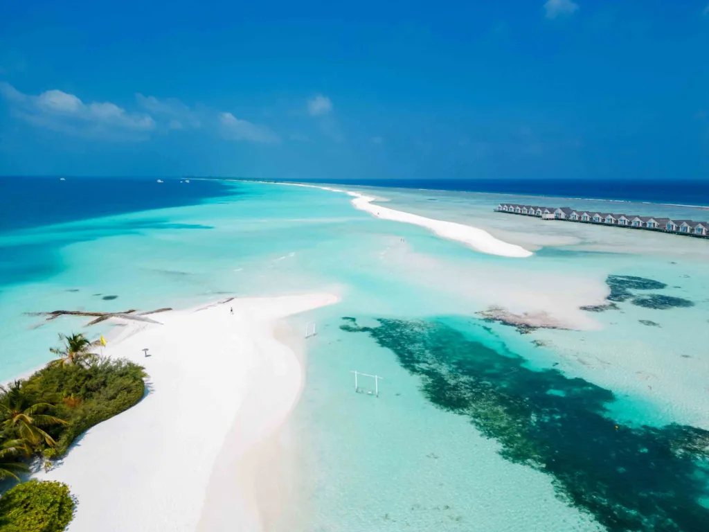 Aerial view of Dhigurah, Maldives, showing white sandy shores surrounded by clear turquoise waters.